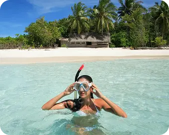 Женщина плавает в прозрачном море на отдыхе