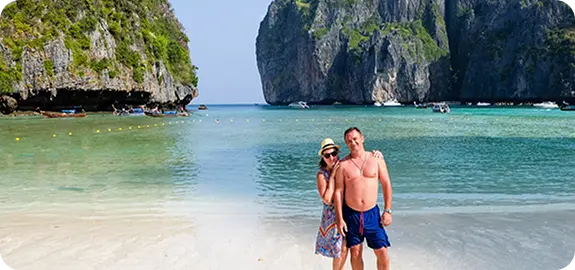 Пара туристов отдыхает на пляже у скал